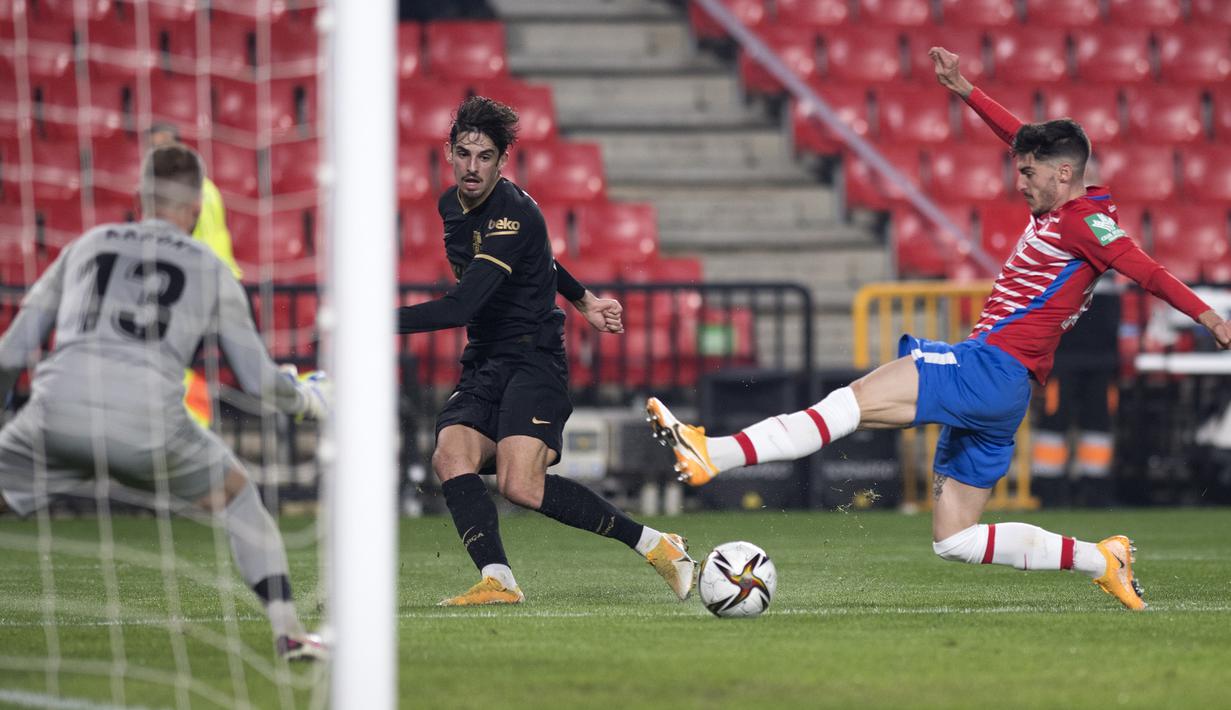 Striker Barcelona, Francisco Trincao (tengah) melepaskan umpan di daerah pertahanan Granada dalam laga perempatfinal Copa del Rey 2020/21 di Nuevo Los Carmenes Stadium, Rabu (3/2/2021). Barcelona menang 5-3 (2-2) atas Granada melalui babak extra time. (AFP/Jorge Guerrero)