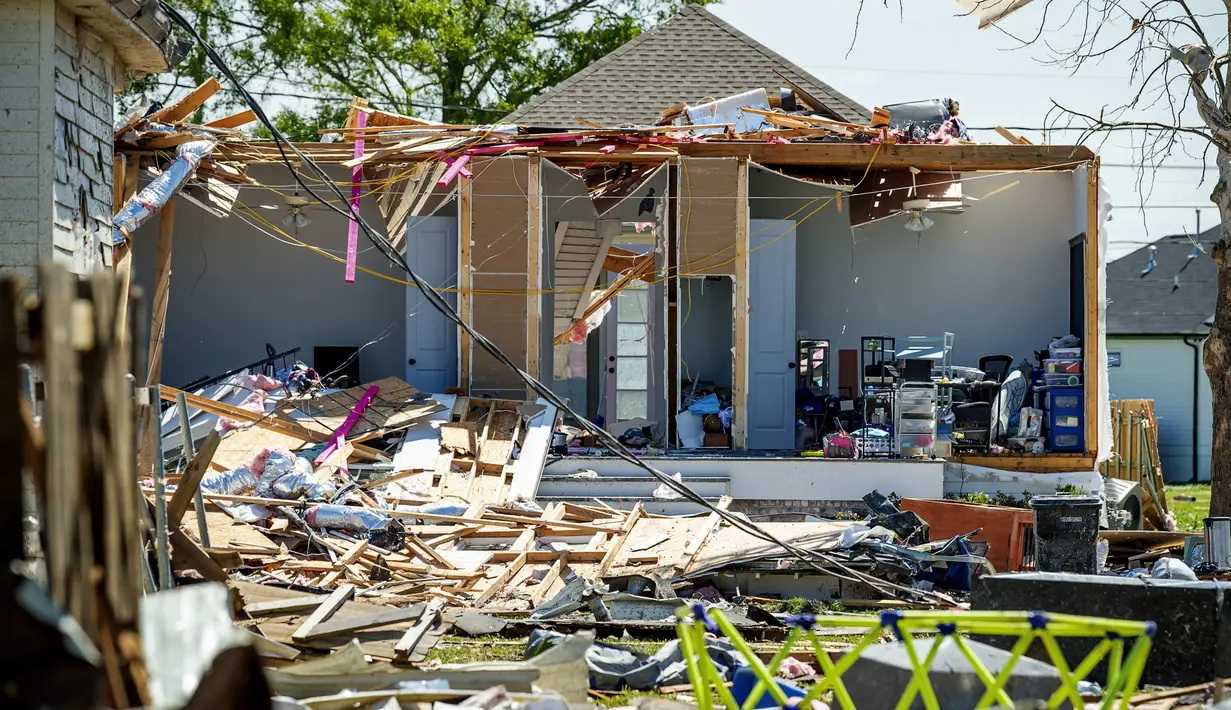 Puing-puing berserakan di tanah di samping rumah yang rusak parah setelah tornado melanda daerah itu Selasa (22/3) malam sebelumnya di Arabi, La., Rabu (23/3/2022). (Scott Clause/The Daily Advertiser via AP)