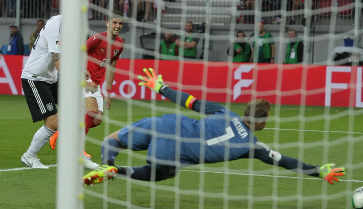 Kiper Jerman, Manuel Neuer, berusaha menepis bola tendangan gelandang Austria, Florian Grillitsch, pada laga persahabatan di Stadion Woerthersee, Klagenfurt, Sabtu (2/6/2018). Austria menang 2-1 atas Jerman. (Bola.com/Reza Khomaini)