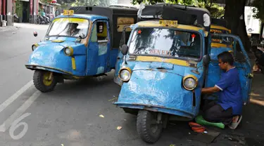 Sopir mengecek kondisi bemo di kawasan Bendungan Hilir, Jakarta, Kamis (22/10/2015). Maraknya perkembangan transportasi online di Ibu Kota membuat keberadaan angkutan bemo kian terpinggirkan akibat kalah bersaing. (Liputan6.com/Immanuel Antonius)