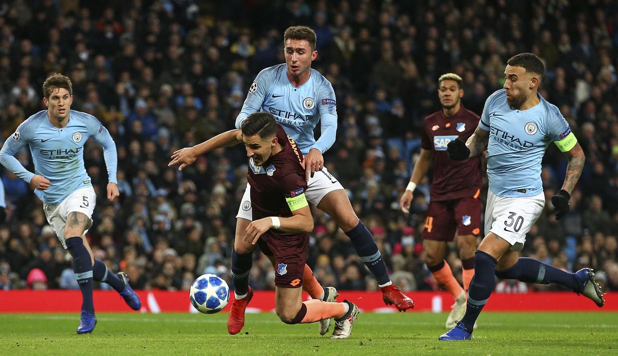 Bek Manchester City, Aymeric Laporte, berusaha merebut bola dari bek Hoffenheim, Benjamin Huebner, pada laga Liga Champions di Stadion Etihad, Rabu (12/12). Manchester City menang 2-1 atas Hoffenheim. (AP/Dave Thompson)