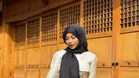 Oklin memamerkan potretnya saat memakai hanbok, pakaian tradisional masyarakat Korea Selatan. Ia melengkapi penampilannya dengan hijab hitam. Selain konten kontroversial, Oklin juga membuat konten traveling. Salah satunya konten tentang kebudayaan Korea Selatan. (Liputan6.com/IG/@oklinfia)