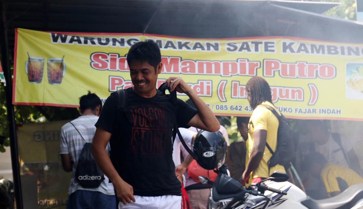 Pelatih Semen Padang, Nil Maizar terlihat antusias menikmati sate kambing Sido Mampir Putro di Solo, Minggu(13/12/2015). (Bola.com/Nicklas Hanoatubun)