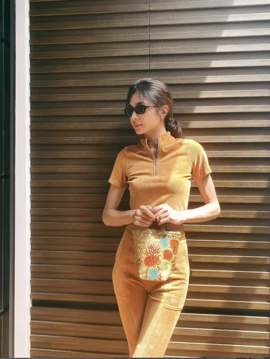 Kali ini ia tamoak begitu stylish dengan aksesori pemanis. Mengenakan tas anyam yang dilukis, semakin menampilkan semarak gaya etnik yang tak terbantahkan. [Foto: Instagram/ Mikha Tambayong]
