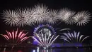 Kembang api meledak di atas kincir London Eye Ferris di Sungai Thames di London, untuk menandai awal tahun baru, Rabu (1/1/2020). (AP Photo/Matt Dunham)