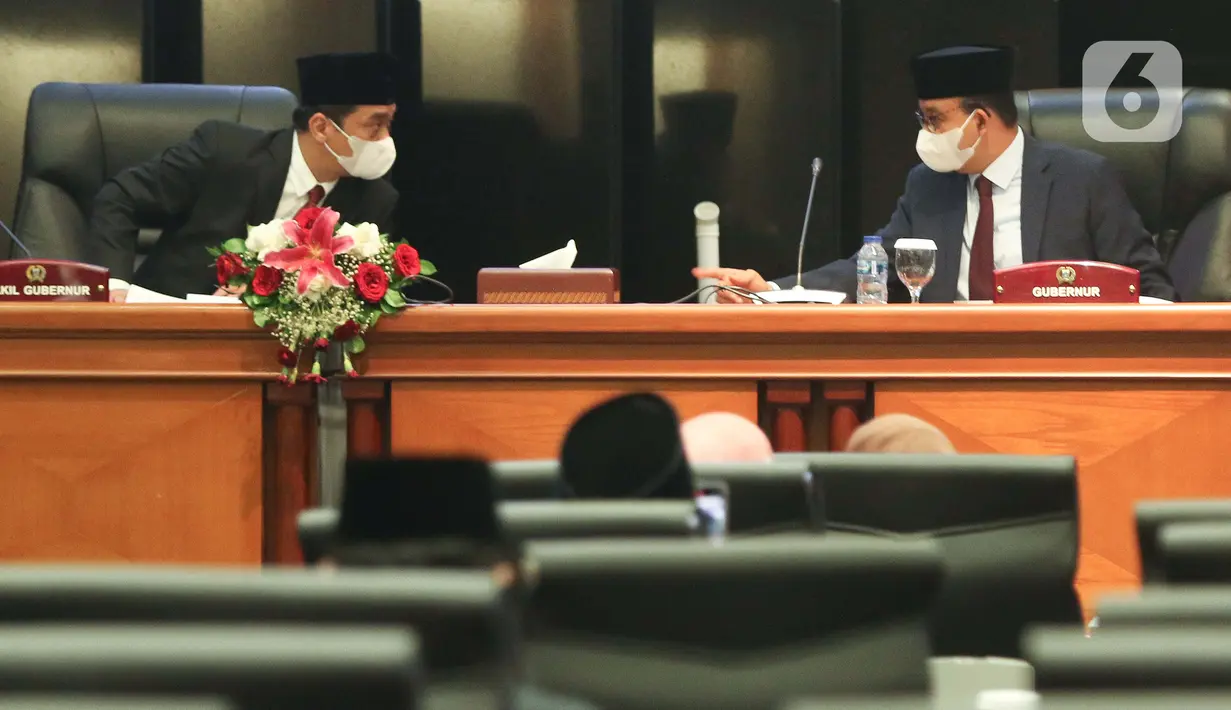 Gubernur DKI Jakarta Anies Baswedan (kanan) bersama Wakil Gubernur DKI Jakarta Ahmad Riza Patria (kiri) berbincang saat mengikuti sidang paripurna di Gedung DPRD DKI Jakarta, Selasa (13/9/2022). DPRD DKI Jakarta menggelar rapat paripurna pengumuman masa akhir kepemimpinan Gubernur DKI Jakarta Anies Baswedan - Ahmad Riza Patria 30 hari sebelum masa tugas berakhir. Rapat paripurna pengumuman pemberhentian Anies ini dilakukan sesuai Surat Edaran Kementerian Dalam Negeri Nomor 131/2188/OTDA.  (Liputan6.com/Herman Zakharia)