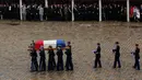 Anggota kepolisian Prancis menggotong peti mati Letnan Kolonel Arnaud Beltrame dalam upacara pemakaman nasional di Hotel des Invalides, Paris, Rabu (28/3). Peti mati Beltrame disambut ratusan orang dalam upacara tersebut. (Ludovic Marin, Pool via AP)