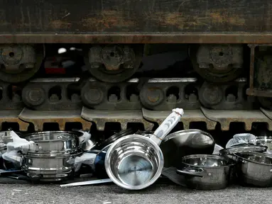 Sebuah alat berat dioperasikan untuk menghancurkan panci palsu dan peralatan dapur yang disita Badan Bea Cukai Swiss di Jenewa, Swiss, (16/6/2015). (REUTERS/Pierre Albouy)