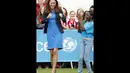 Salah satu anak menyambut keberhasilan Duchess of Cambridge, Kate Middleton, memainkan permainan asli Afrika Selatan "Tiga Kaleng" di Commonwealth Games Village di Glasgow, Skotlandia, (29/7/2014). (REUTERS/Danny Lawson)