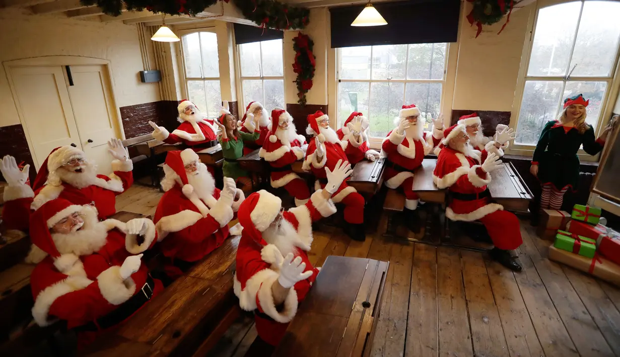 Sejumlah pria mengenakan kostum Santa Claus terlihat beradegan sedang belajar saat sesi pemotretan di Ragged School Museum di London (16/11). Mereka melakukan sesi pemotretan untuk Ministry of Fun Santa School. (AP Photo/Matt Dunham)