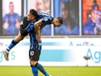 Striker Inter Milan, Lautaro Martinez, melakukan selebrasi bersama Achraf Hakimi usai mencetak gol ke gawang Crotone pada laga Liga Italia di Stadion Giuseppe Meazza, Minggu (3/1/2021). Inter Milan menang dengan skor 6-2. (AP/Antonio Calanni)