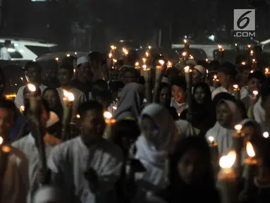 Warga membawa obor saat pawai Tahun Baru Islam 1440 H di kawasan Menteng, Jakarta, Senin (10/9). Pawai obor yang diiringi musik bernuansa Islam merupakan tradisi umat muslim di Indonesia menyambut Tahun Baru 1 Muharram. (Merdeka.com/Iqbal S Nugroho)