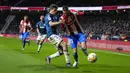 Gelandang Atletico Madrid Yannick Carrasco berebut bola dengan bek Deportivo Alaves Nahuel Tenaglia dalam lanjutan La Liga Spanyol, Minggu (3/4/2022) dinihari WIB. Atletico Madrid menang telak dengan skor 4-1 atas Deportivo. (AP Photo/Manu Fernandez)