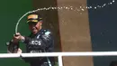 Pembalap Mercedes Lewis Hamilton merayakan kemenangannya pada Formula 1 Grand Prix di Sirkuit Interlagos, Sao Paulo, Brasil, 14 November 2021. Lewis Hamilton di urutan pertama, Max Verstappen kedua, dan Valtteri Bottas ketiga. (Lars Baron, Pool Photo via AP)