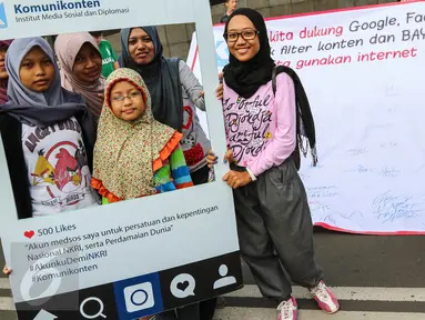 Warga pose saat aksi penandatanganan spanduk dukungan di Car Free Day Jalan MH Thamrin, Jakarta, Minggu (25/9). Aksi tersebut mengajak Facebook, Google, YouTube dan Twitter untuk bayar pajak. (Liputan6.com/Fery Pradolo)