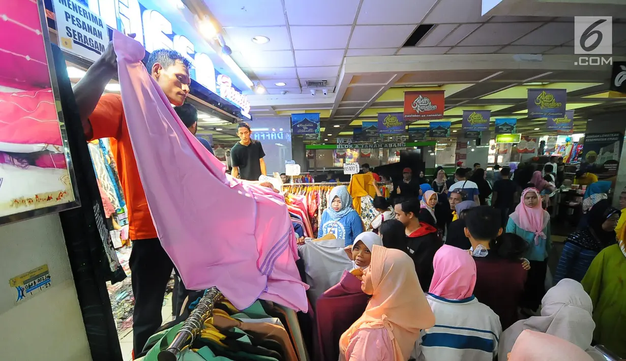 Pedagang melayani pembeli di pasar Tanah Abang, Jakarta, Minggu (26/5/2019). Jelang lebaran masyarakat mulai memadati pusat perbelanjaan untuk membeli kebutuhan saat Hari Raya Idul Fitri. (Liputan6.com/Angga Yuniar)