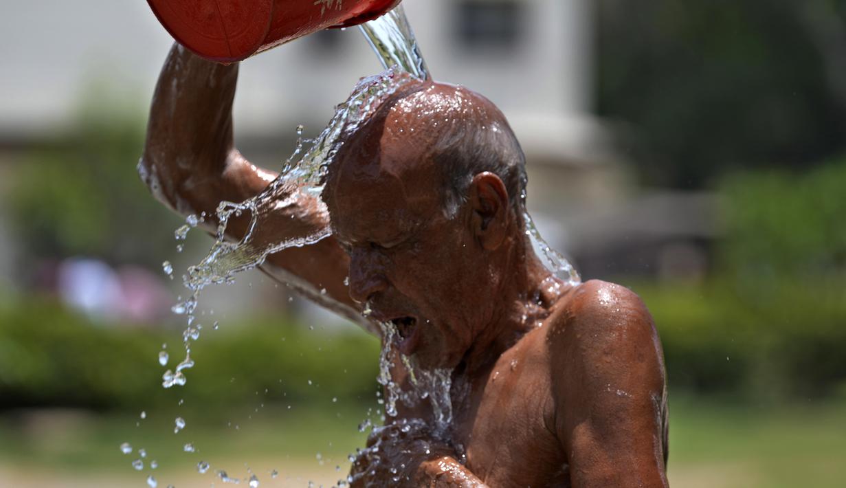 Seorang pria mendinginkan diri di tengah cuaca panas di sebuah taman di Karachi, Pakistan, Selasa (21/5/2024). (AP Photo/Fareed Khan)