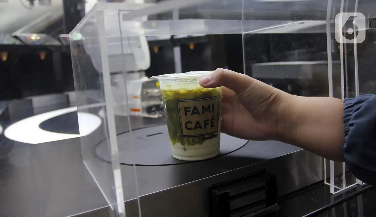 Pelanggan mengambil pesanan minuman buatan robot barista di Family Mart, Grand Indonesia East Mall, Jakarta, Senin (10/1/2022). Robot barista mampu membuat aneka minuman produk FamilyMart seperti Kopi Susu Keluarga, Dolce Latte, Premium Chocolate, dan Green Tea. (merdeka.com/Arie Basuki)