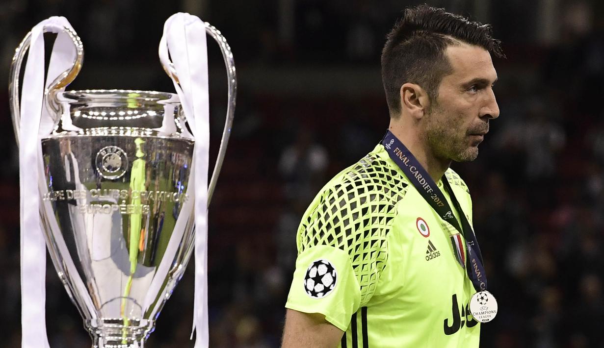 Kiper Juventus, Gianluigi Buffon, tampak sedih ketika melewati piala Liga Champions di Stadion Millennium, Sabtu (3/6/2017). Juventus kalah 1-4 dari Real Madrid. (AFP/Javier Soriano)