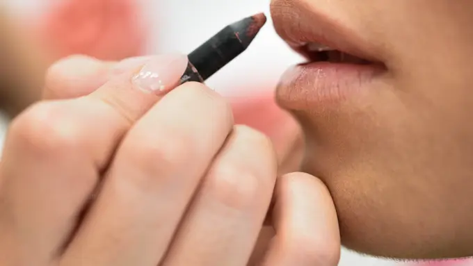 Seorang perempuan sedang mengaplikasikan lip liner di bibirnya (Foto Dok: Freepik/javi_indy)