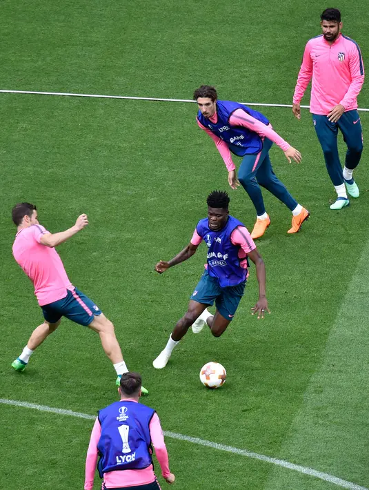 Gelandang Atletico Madrid, Thomas (tengah) membawa bola saat sesi latihan di Decines-Charpieu (15/5). Atletico Madrid akan bertanding melawan wakil Prancis, Marseille pada babak final Liga Europa. (AFP Photo/Jean-Philippe Ksiazek)