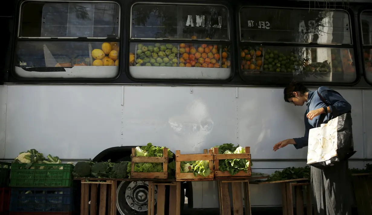 Seorang wanita memilih sayuran saat berbelanja di pasar bus 'Sacolao' di Santa Teresa, Rio de Janeiro, Brasil, Selasa (7/7/2015). Pasar bus ini menjual sayur dan buah-buahan dengan harga yang terjangkau. (REUTERS/Pilar Olivares)