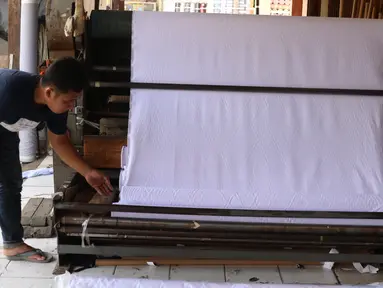 Pedagang merapikan bahan kain yang akan dijual di kawasan Tangerang, Banten, Sabtu (25/9/2021). Kementerian Perindustrian memberikan stimulus bagi industri tekstil dalam negeri berupa program Restrukturisasi Mesin/Peralatan Industri Penyempurnaan dan Percetakan Kain. (Liputan6.com/Angga Yuniar)