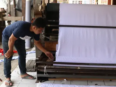 Pedagang merapikan bahan kain yang akan dijual di kawasan Tangerang, Banten, Sabtu (25/9/2021). Kementerian Perindustrian memberikan stimulus bagi industri tekstil dalam negeri berupa program Restrukturisasi Mesin/Peralatan Industri Penyempurnaan dan Percetakan Kain. (Liputan6.com/Angga Yuniar)