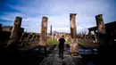 Seorang wisatawan melihat Sanctuary of Apollo, Pompeii, Italia, Senin (25/11/2019). Pompeii adalah kota zaman Romawi Kuno yang hancur oleh letusan Gunung Vesuvius pada 79 M. (Filippo MONTEFORTE/AFP)