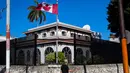 Seorang pria melintas di samping kedutaan besar Kanada yang berada di Hanava, Kuba, Selasa (17/3).  Kanada memulangkan staf diplomat beserta keluarga mereka dari Kuba karena terserang penyakit misterius. (AP/Desmond Boylan)