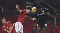 Bek Manchester United, Harry Maguire berebut bola dengan pemain Aston Villa, Keinan Davis pada pertandingan lanjutan Liga Inggris di stadion Old Trafford, Inggris  (2/1/2021). Pasukan Ole Gunnar Solskjaer baru bisa menjebol gawang Villa lima menit jelang turun minum. (Lawrence Griffiths / Pool via A
