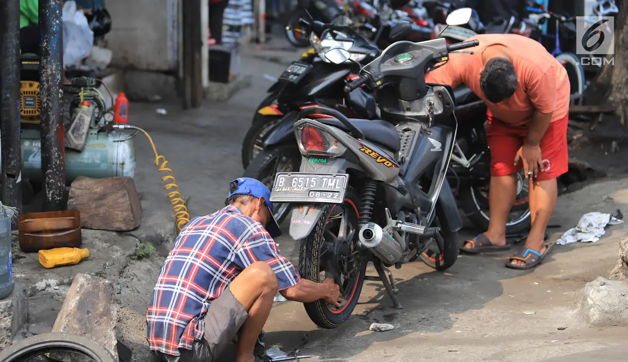 Mekanik mengecek motor pelanggan di sebuah bengkel di Otista, Jakarta, Minggu (10/6). Calon pemudik motor mulai memenuhi bengkel guna menyervis atau mengganti suku cadang kendaraan sebelum digunakan untuk mudik Lebaran. (Liputan6.com/Angga Yuniar)