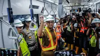 Gubernur DKI Jakarta Anies Baswedan saat mencoba Moda Raya Terpadu (MRT) dari Stasiun Bundaran HI-Lebak Bulus, Jakarta, Senin (10/12). Anies terlihat banyak tersenyum selama perjalanan. (Liputan6.com/Faizal Fanani)