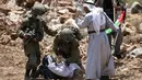 Tentara Israel membekuk pengunjuk rasa Palestina di dekat Desa Shoufah, wilayah Tepi Barat yang diduduki Israel (20/8/2020). Tentara Israel menangkap pengunjuk rasa yang kembali beraksi menentang pembukaan lahan sebagai bagian dari proyek permukiman Israel di wilayahnya. (AFP/JAAFAR ASHTIYEH)