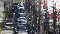 Kabel utilitas semrawut melintang di atas Jalan Ciledug Raya, Kawasan Seskoal, Kebayoran Lama, Jakarta, Selasa (8/8/2023). (Liputan6.com/Johan Tallo)