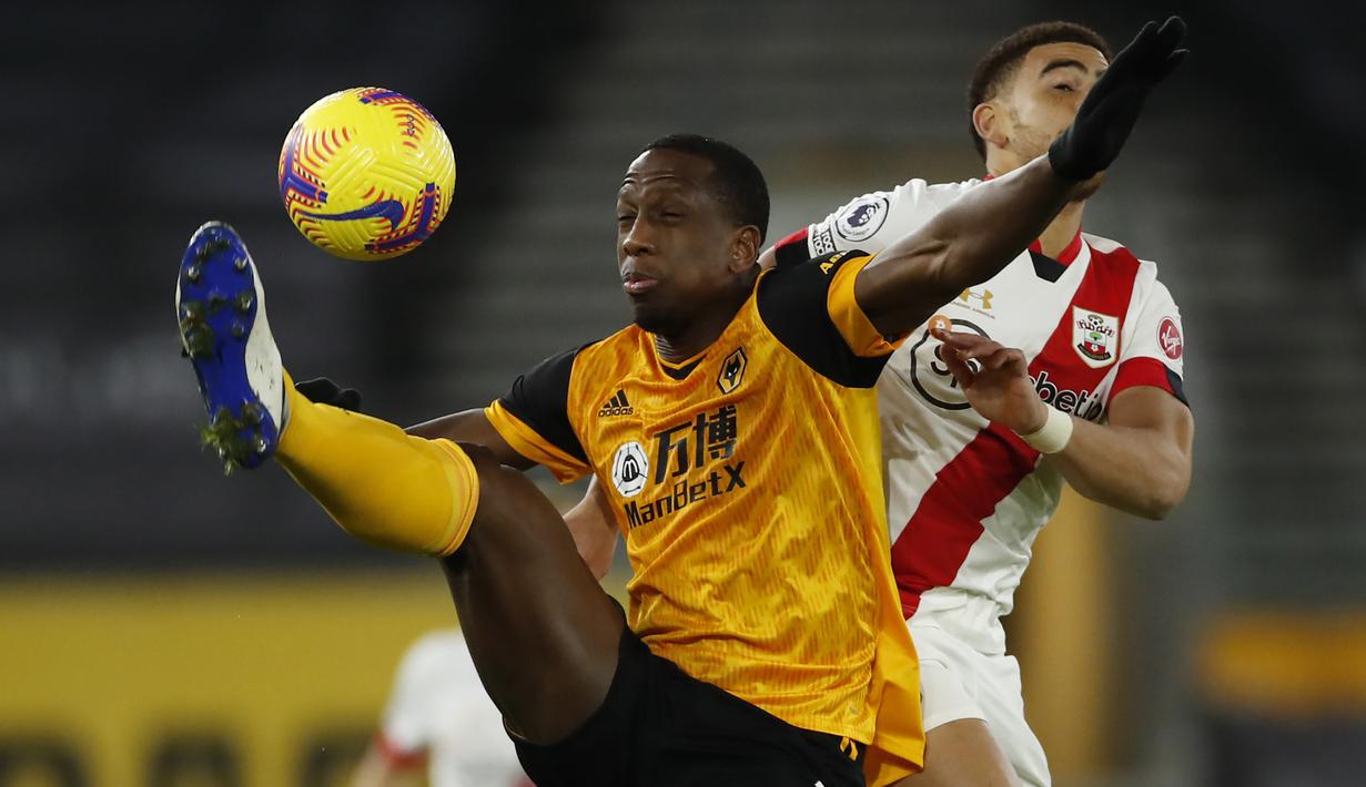Bek Wolverhampton Wanderers, Willy Boly, berebut bola dengan gelandang Southampton, Che Adams, pada laga lanjutan Liga Inggris di Molineux Stadium, Selasa (24/11/2020) dini hari WIB. Wolverhampton imbang 1-1 menghadapi Southampton. (AFP/Andrew Boyers/pool)
