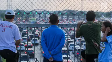 Warga melihat kemacetan arus lalu lintas di Gerbang Tol Utama Palimanan, Cirebon, Jawa Barat, Kamis (29/6). Menjelang sore hari warga berwisata sambil menyaksikan kemacetan volume kendaraan saat arus balik menuju Jakarta. (Liputan6.com/Faizal Fanani)