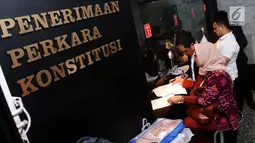 Sejumlah pengacara dari ACTA mendaftarkan permohonan uji materi Undang-undang ITE ke MK, Jakarta, Senin (18/9). Uji materi ini karena prihatin banyak aktivis yang terjerat masalah hukum karena mengkritik di media sosial. (Liputan6.com/Angga Yuniar)