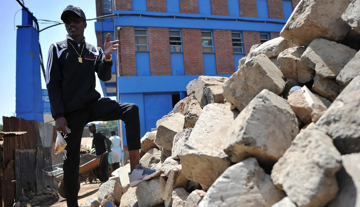 Artis hip hop Kenya Henry Ohanga berdiri di tempat di mana rumah keluarganya pernah berdiri yang sekarang merupakan lokasi konstruksi untuk sekolah amal untuk anak-anak yang kurang beruntung di Kibera, Nairobi, Kenya (16/1). (AFP Photo/Tony Karumba)