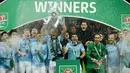 Pemain Manchester City, Vincent Kompany mengangkat trofi Piala Liga Inggris seusai mengalahkan Arsenal di Stadion Wembley, Minggu (25/2). Trofi Piala Liga Inggris musim ini adalah yang kelima dalam sejarah Manchester City. (AP/Tim Ireland)