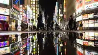 Orang-orang berjalan melalui distrik hiburan Kabukicho yang terkenal di Tokyo pada malam pertama pencabutan status darurat virus corona oleh pemerintah Jepang, Jumat (1/10/2021). (AP hoto/Hiro Komae)