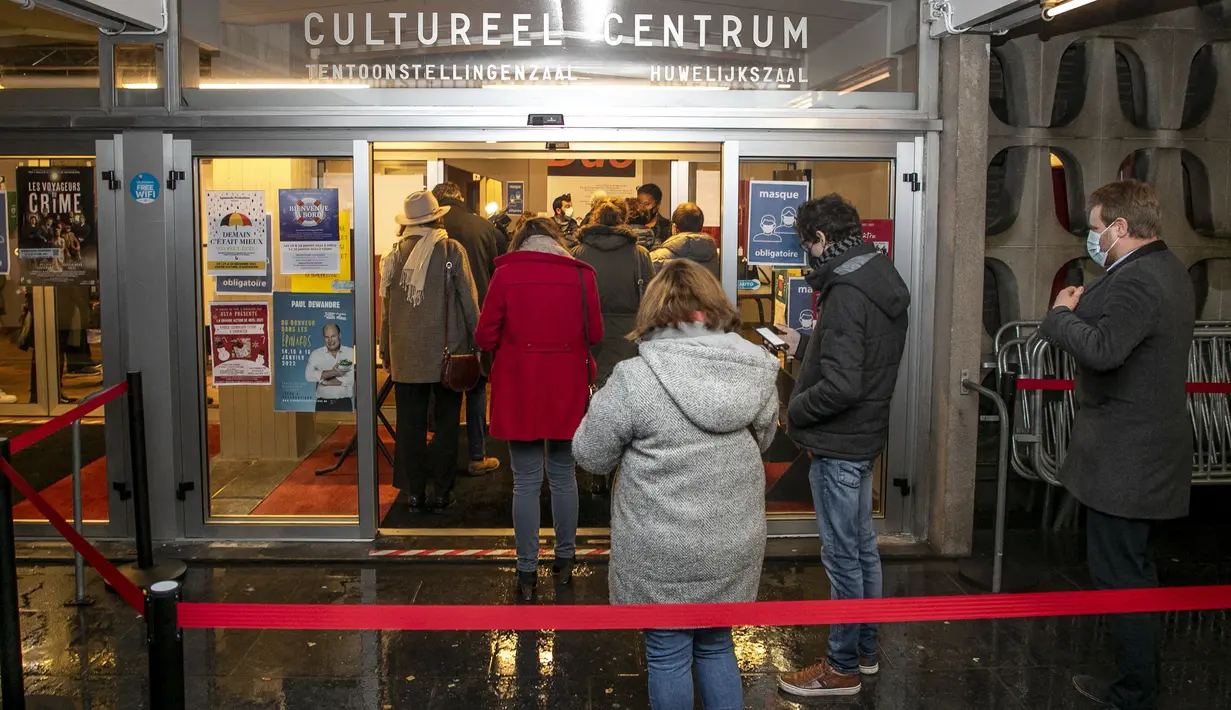 Orang-orang tiba untuk menonton sebuah pementasan di venue Centre Culturel di Brussels, Rabu (29/12/2021). Otoritas Belgia mengonfirmasi pembukaan kembali teater dan bioskop setelah pengadilan memenangkan gugatan dari sektor budaya terhadap penutupan venue-venue budaya. (HATIM KAGHAT/BELGA/AFP)