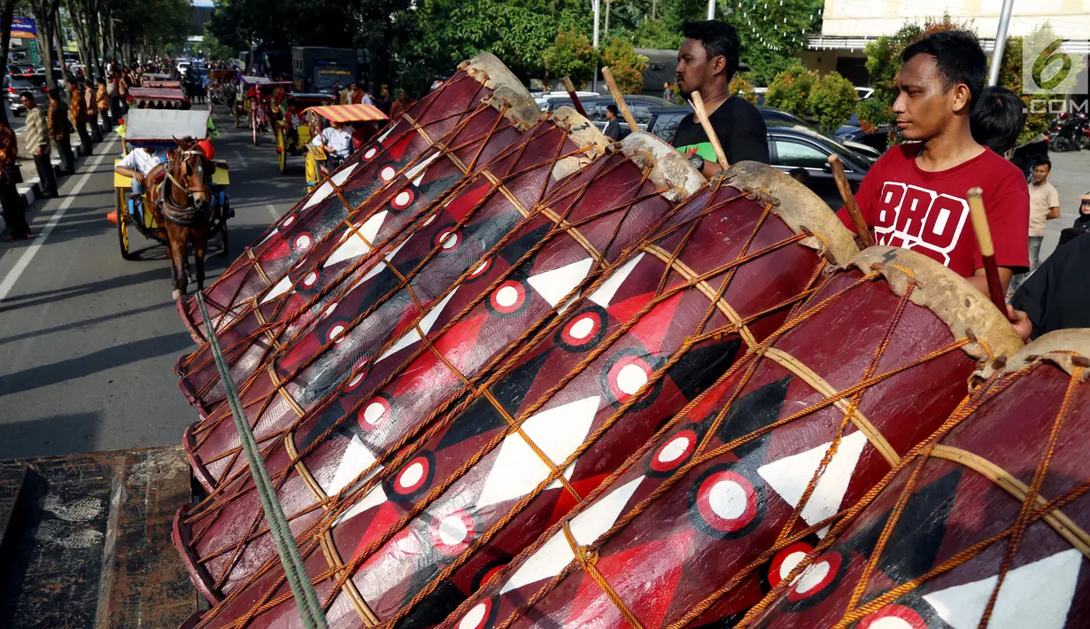 Sejumlah warga memukul beduk saat mengikuti geladi resik kirab ngunduh mantu Kahiyang-Bobby di Medan, Rabu (22/11). Rute kirab dimulai dari Jalan Ring Road menuju lokasi resepsi di Perumahan Bukit Hijau Regency. (Liputan6.com/Johan Tallo)
