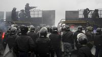 Polisi anti huru hara memblokir jalan untuk menghentikan demonstran selama protes di Almaty, Kazakhstan, Rabu (5/2/2022). Demonstran yang menolak kenaikan harga gas cair bentrok dengan polisi di kota terbesar Kazakhstan dan mengadakan protes di sekitar kota. (AP Photo/Vladimir Tretyakov)