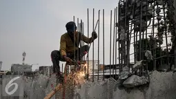 Pekerja memotong besi sheet pile yang terpasang di Kali Sunter, Kemayoran, Jakarta, Selasa (26/7). Pemasangan turap terus dikebut untuk mencegah terjadinya banjir di musim penghujan.(Liputan6.com/Yoppy Renato)