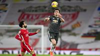 Bek Manchester United, Harry Maguire, berebut bola dengan pemain Liverpool, Mohamed Salah, pada laga Liga Inggris di Stadion Anfield, Minggu (17/1/2021). Kedua tim bermain imbang 0-0. (Michael Regan/Pool via AP)