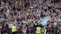 Sejumlah pemain dan penggemar Manchester City merayakan kemenangan 2-1 atas Fulham dalam pertandingan pekan ke-34 Premier League 2022/2023 yang berlangsung di Craven Cottage, Minggu (30/4/2023). Kemenangan tim asuhan Pep Guardiola tersebut berhasil menggeser posisi Arsenal dari puncak klasemen sementara Liga Inggris 2022/2023. (AP Photo/Kin Cheung)