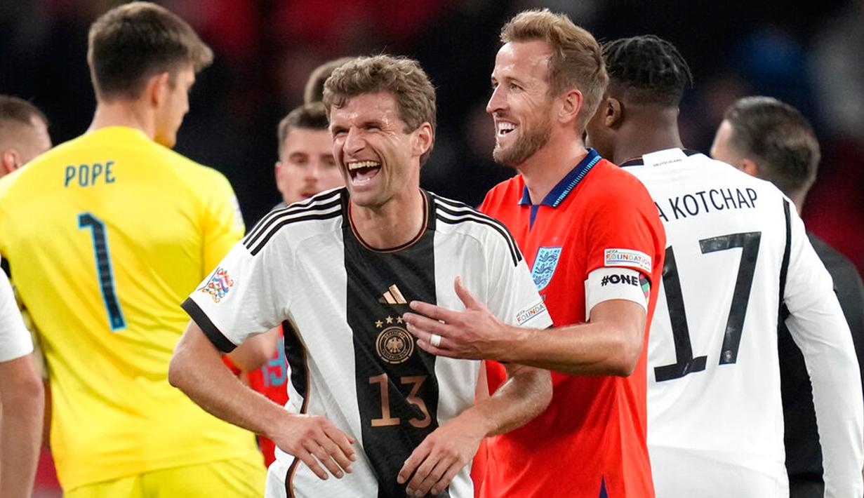 Pemain Jerman Thomas Muller tertawa dengan pemain Inggris Harry Kane pada akhir pertandingan sepak bola UEFA Nations League di Stadion Wembley, London, Inggris, 26 September 2022. Pertandingan berakhir imbang 3-3. (AP Photo/Kirsty Wigglesworth)