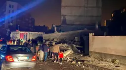 Orang-orang melihat kerusakan bangunan setelah gempa bumi di Durres,  Albania barat, Selasa (26/11/2019). Gempa bumi bermagnitudo 6,4 mengguncang Albania, Selasa dini hari yang menyebabkan beberapa bangunan dan gedung permukiman runtuh. (AP Photo)