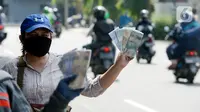 Penjual jasa penukaran uang menawarkan uang baru berbagai pecahan kepada pengguna jalan di kawasan Bintaro Sektor 2, Jakarta Selatan, Selasa (12/05/2020). Menjelang perayaan Lebaran, jasa penukar uang keliling yang berada di pinggir jalan-jalan utama mulai bermunculan. (merdeka.com/Dwi Narwoko)